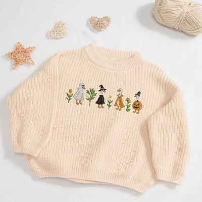 Beige sweater with embroidered design on a light gray background