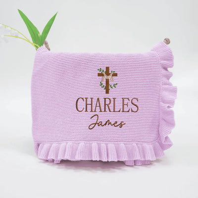 Purple blanket with embroidered name and cross design on a white background