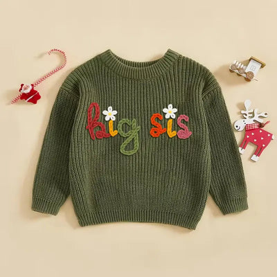 Green sweater with 'Big Sis' text on a beige background