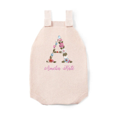 Pink knitted romper with floral letter 'A' and name 'Amelia Kate' on a white background