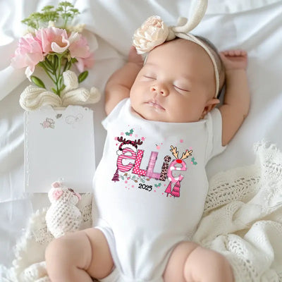 Baby wearing a white onesie with decorative text, surrounded by flowers and lace on a white background