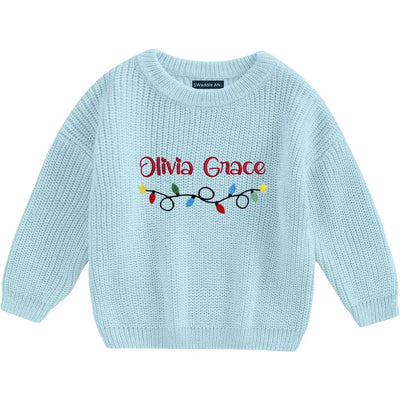 Light blue sweater with 'Olivia Grace' and Christmas lights design on a white background