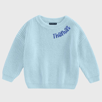 Light blue sweater with 'Thomas' embroidered on a light gray background