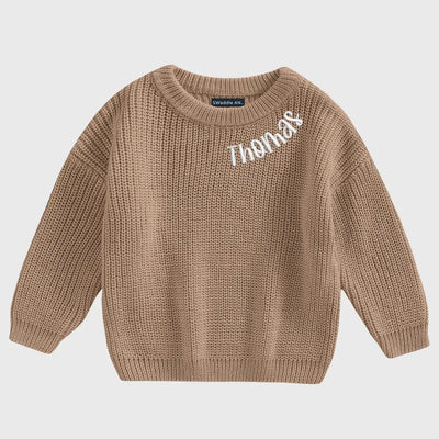 Brown knitted sweater with 'Thomas' embroidered on a light gray background