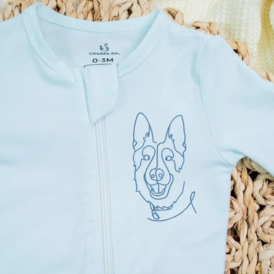 Light blue baby onesie with a dog illustration on a woven surface