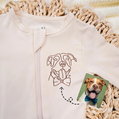 Baby onesie with a printed design of a dog wearing a bow tie, placed on a textured surface.