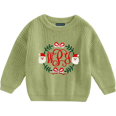 Green knitted sweater with Christmas design and monogram on a white background