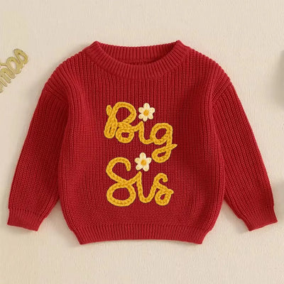 Red sweater with 'Big Sis' text and flowers on a beige background
