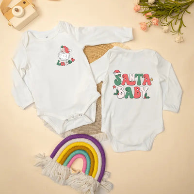 Two baby onesies with Christmas designs on a beige background