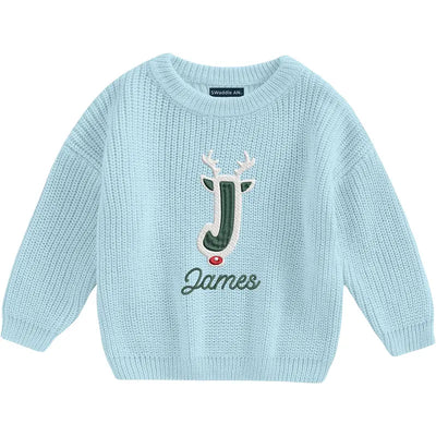 Light blue sweater with a reindeer design and name 'James' on a white background
