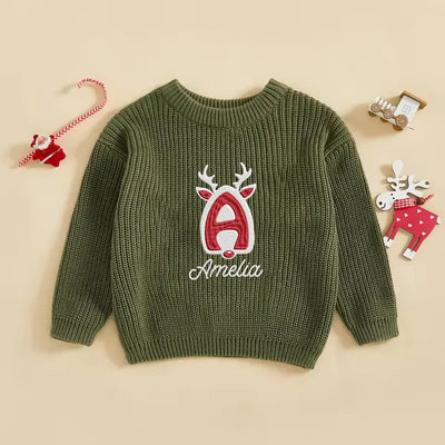 Green sweater with reindeer design and 'Amelia' text on a beige background
