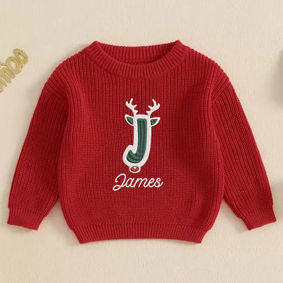 Red sweater with a reindeer design and 'James' text on a beige background