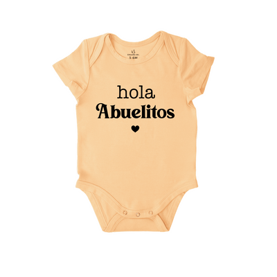 Beige baby onesie with 'Hola Abuelitos' text on a white background