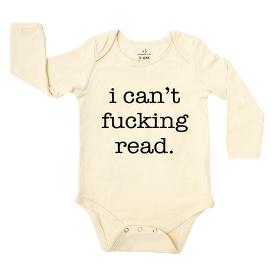 Beige baby onesie with black text 'i can't fucking read' on a white background