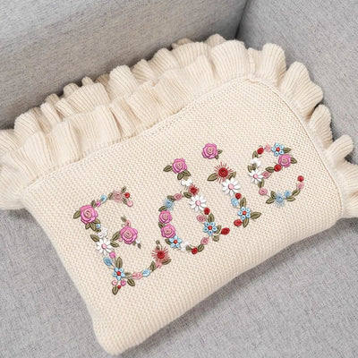 Personalized Floral Knit Baby Blanket is more than a cozy wrap; it is a blooming garden of comfort, where delicate flowers are embroidered around their name