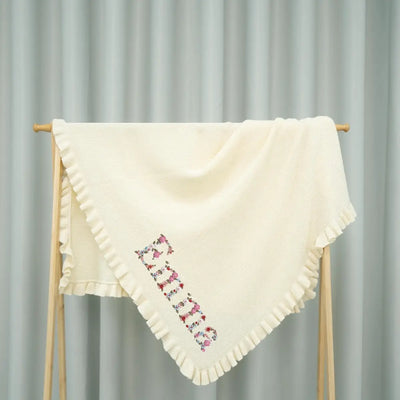 Personalized Floral Knit Baby Blanket is more than a cozy wrap; it is a blooming garden of comfort, where delicate flowers are embroidered around their name
