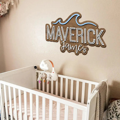 Wooden name sign above a crib with baby toys in a nursery