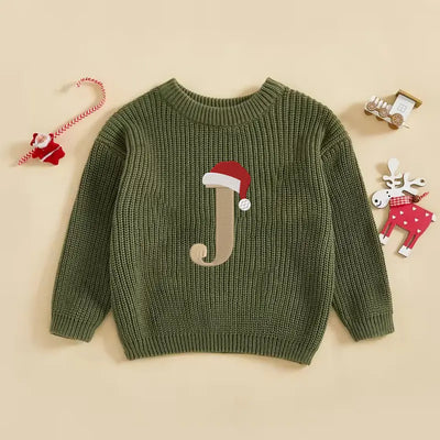 Green sweater with letter 'J' and Santa hat on a beige background