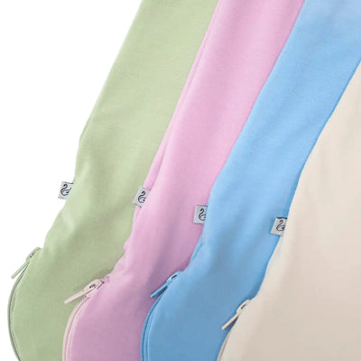 Four pastel-colored cushions in green, pink, blue, and beige on a white background.