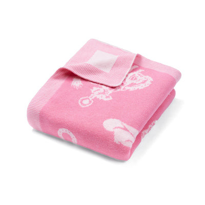 Pink baby blanket with white patterns on a white background