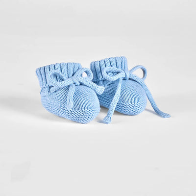 Pair of blue knitted baby booties on a light gray background