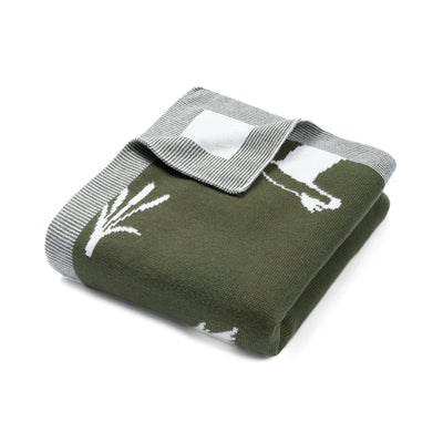Green blanket with white floral pattern on a white background