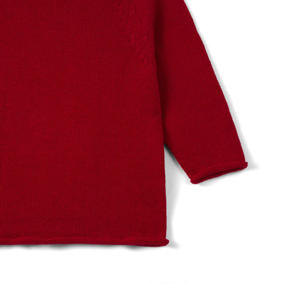 Close-up of a red sweater sleeve on a white background