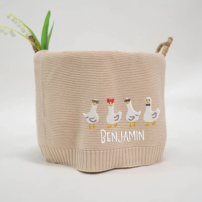 Beige personalized baby basket with embroidered geese and 'Benjamin' text on a white background