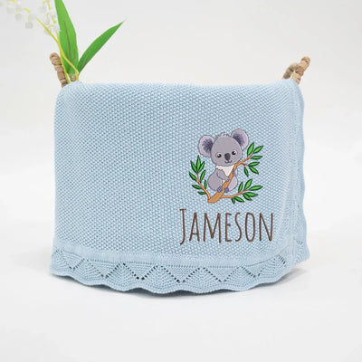Light blue personalized baby blanket with a embroidered koala and name 'Jameson' on a white background.
