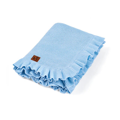 Light blue knitted blanket with ruffled edge on a white background