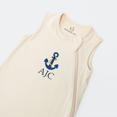 Sand baby sleep sack with blue anchor and 'AJC' text on a white background