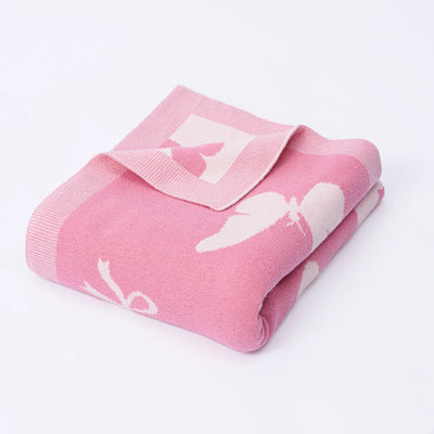 Pink baby blanket with white cloud pattern on a light gray background