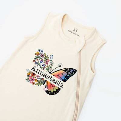 Sand baby sleep sack with a colorful butterfly design and 'Annastasia' text on a white background