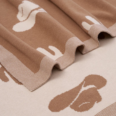 Close-up of a brown and beige fabric with animal prints on a matching background.