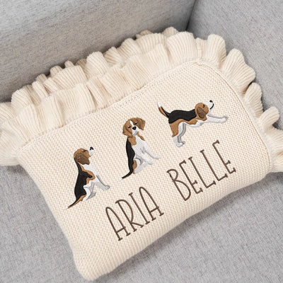 Cream personalized baby blanket with embroidered beagle puppy designs and 'Aria Belle' text on a gray surface.
