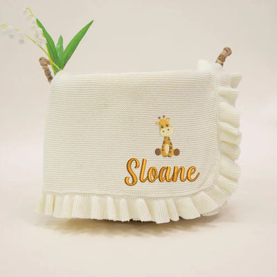 Cream personalized baby blanket with a giraffe design and 'Sloane' text on a beige background