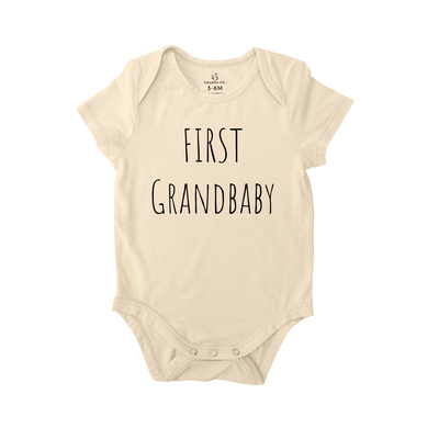 Beige baby onesie with 'First Grandbaby' text on a white background