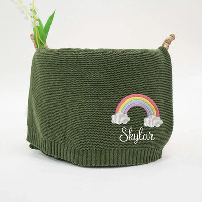 Forest green personalized baby blanket with rainbow and cloud design, embroidered with 'Skyler', on a white background.