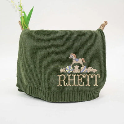 Forest green personalized baby blanket with embroidered rocking horse design and 'RHETT' text on a white background