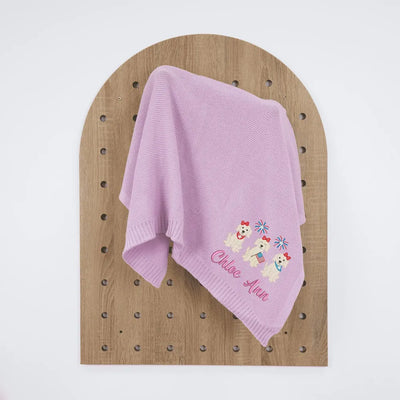 Lilac personalized baby blanket with embroidered patriotic puppy trio designs on a wooden board
