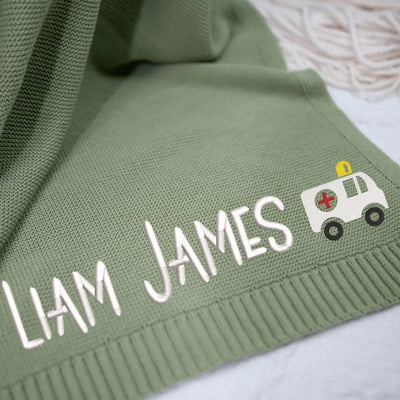 Sage green personalized baby blanket with embroidered name 'LIAM JAMES' and ambulance car icon.