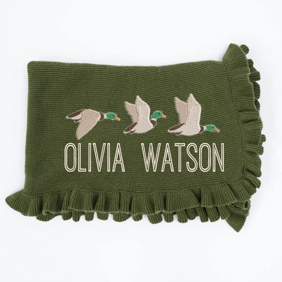 Forest green personalized blanket with embroidered name 'Olivia Watson' and mallard duck designs on a white background
