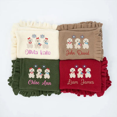 Four folded personalized baby blankets with embroidered patriotic puppy trio designs and names on a white background