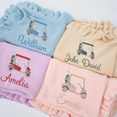 Stack of personalized baby girl blankets with golf cart designs and names on a white background