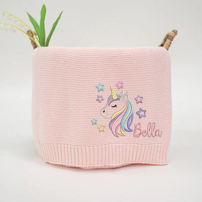 Pink personalized baby blanket with a unicorn design and 'Bella' text on a white background