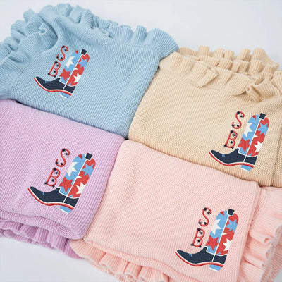 Four personalized baby blankets with ruffled edges and embroidered USA star cowboy boot designs in various colors.