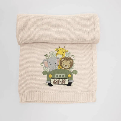 Beige personalized baby blanket with embroidered design of woodland adventure awaits on a light gray background