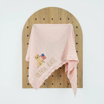 Pink personalized baby blanket with embroidered patriotic golden retriever design and text on a wooden board