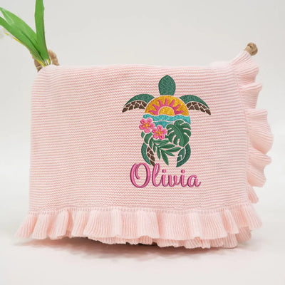 Pink personalized baby blanket with a sea turtle design and 'Olivia' text on a white background