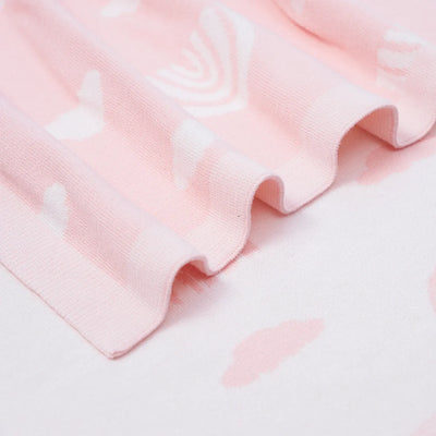 Close-up of pink fabric with heart patterns on a light gray background